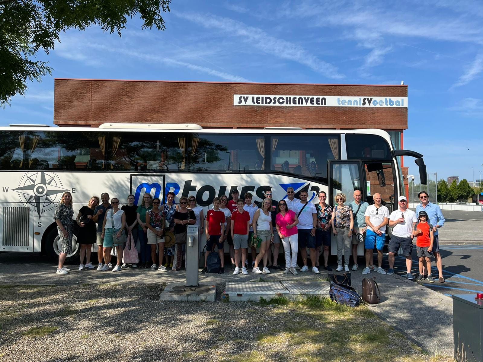 Groep bij de MRTours-bus voor een clubuitje